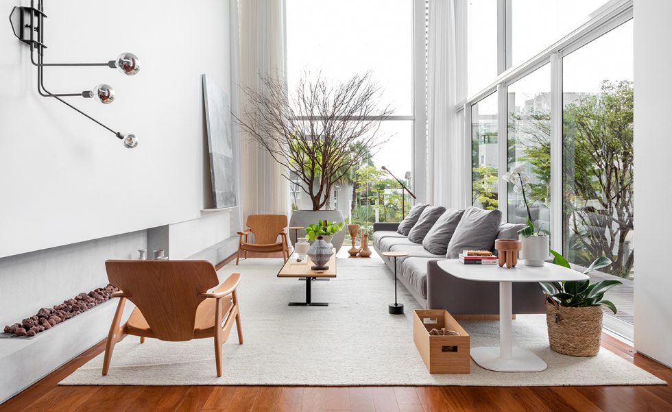 A sala principal da casa recebeu uma oliveira de três metros, complementada pelo paisagismo da área externa. Minimalista, a arquiteta apostou em peças de design assinado. A dupla de poltronas Diz, de Sérgio Rodrigues, foram posicionadas em lados opostos da sala. Sofá, mesa de centro, mesa lateral e luminária são assinados por Jader Almeida A sala principal da casa recebeu uma oliveira de três metros, complementada pelo paisagismo da área externa. Minimalista, a arquiteta apostou em peças de design assinado. A dupla de poltronas Diz, de Sérgio Rodrigues, foram posicionadas em lados opostos da sala. Sofá, mesa de centro, mesa lateral e luminária são assinados por Jader Almeida