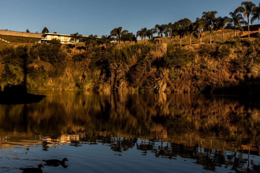 Inserida entre uma área urbana, fortemente ocupada e uma unidade de preservação ambiental, a residência foi posicionada no terreno de forma a sempre orientar a visão do usuário em relação à natureza