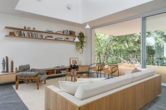 Grandes aberturas conectam a sala ao deck e ao bosque ao redor.